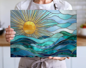 May include: A rectangular stained glass panel depicting a sunrise over ocean waves. The sun is a golden yellow circle with radiating yellow rays. The waves are shades of blue and teal, creating a serene, artistic scene.