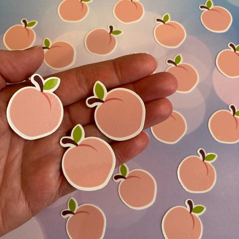 Peut inclure: Une collection d'autocollants de couleur p&ecirc;che avec un contour simple d'une p&ecirc;che. Les autocollants sont dispos&eacute;s de mani&egrave;re al&eacute;atoire sur un fond violet clair.