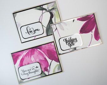 May include: Three greeting cards with floral designs and text. The cards have a white background with watercolor-style flowers in shades of pink, purple, and green. Each card has a rectangular label with a message: "for You", "Thinking of You", and "You are in my thoughts."