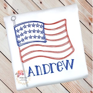 K&ouml;nnte beinhalten: Gestickte Darstellung einer amerikanischen Flagge mit dem Namen Andrew darunter. Die Flagge ist rot, wei&szlig; und blau und weht im Wind.