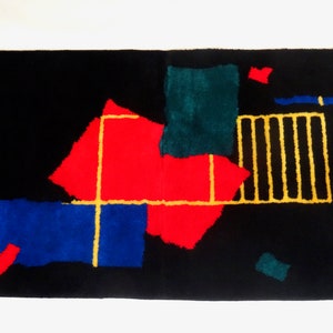 Könnte beinhalten: Abstrakter Teppich mit geometrischen Formen in Rot, Blau, Grün und Gelb auf schwarzem Hintergrund.