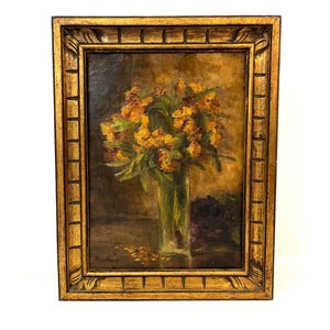 Könnte beinhalten: Ölgemälde eines Blumenarrangements in einer klaren Glasvase, vor dunklem Hintergrund. Die Blumen sind gelb und orange, mit grünen Blättern. Das Gemälde befindet sich in einem goldenen, verzierten Rahmen.