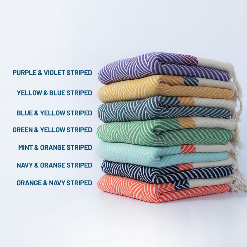 May include: A stack of eight colorful striped towels, each with a different color combination. The towels are folded and stacked on top of each other. The colors are purple and violet, yellow and blue, blue and yellow, green and yellow, mint and orange, navy and orange, and orange and navy.