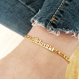 Peut inclure: Bracelet en chaîne dorée avec le nom "Breanna" écrit en lettres anciennes.