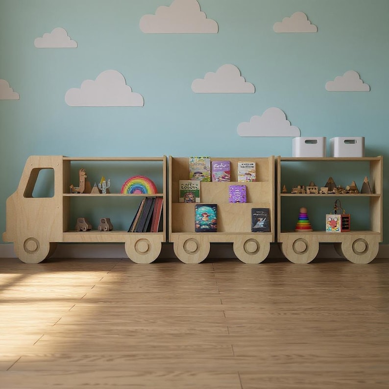 May include: A wooden bookshelf shaped like a truck with three sections. The shelves are filled with books, toys, and decorative items. The background features a light blue wall with white cloud cutouts.