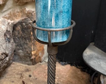 Candelabro de hierro forjado con forma de jaula retorcida, estilo rústico artesanal vintage.