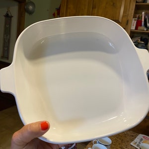 Puede incluir: Plato para hornear de cerámica blanca con bordes redondeados y dos asas. El plato está vacío y parece nuevo.