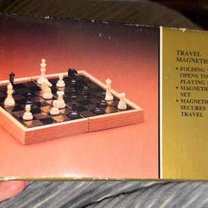 May include: A travel magnetic chess set with a folding wood case. The playing surface opens to 8 inches square. The set includes magnetic chess pieces and a magnetic brass lock to secure the case for travel.