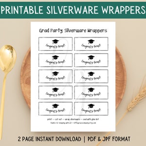 May include: Printable silverware wrappers for a graduation party. The design features black graduation caps and the text "Congrats Grad!" on white rectangles. A gold spoon and wooden plate are in the background.