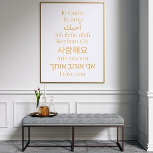 May include: A framed print with the words "I love you" written in multiple languages, including English, French, Spanish, German, Korean, Hebrew, and Arabic. The print is hanging on a white wall with white wainscoting.