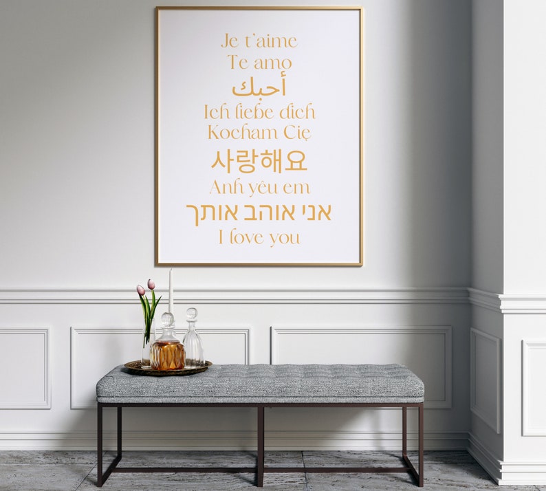 May include: A framed print with the words "I love you" written in multiple languages, including English, French, Spanish, German, Korean, Hebrew, and Arabic. The print is hanging on a white wall with white wainscoting.