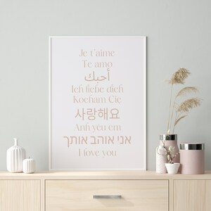 May include: A white framed print with the words "Je t'aime", "Te amo", "أحبك", "Ich liebe dich", "Kocham Cię", "사랑해요", "Anh y&ecirc;u em", "אני אוהב אותך", and "I love you" in different languages.