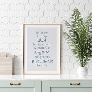 May include: A framed print with a white background and teal text. The text says "Je t'aime, Te amo, أحبك, Ich liebe dich, Kocham Cię, 사랑해요, Anh y&ecirc;u em, אני אוהב אותך, I love you".