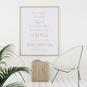 May include: A white framed poster with the words "Je t'aime", "Te amo", "أحبك", "Ich liebe dich", "Kocham Cię", "사랑해요", "Anh y&ecirc;u em", "אני אוהב אותך", and "I love you" written in different languages.