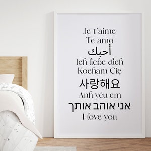 May include: A white framed print with the phrase "I love you" written in 10 different languages, including English, French, Spanish, German, Polish, Arabic, Vietnamese, Korean, and Hebrew.