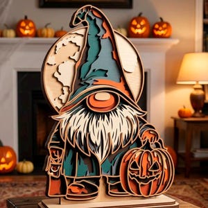 Könnte beinhalten: Ein mehrschichtiger Halloween-Zwerg aus Holz, der einen geschnitzten Kürbis hält. Der Zwerg trägt einen hohen Hut, einen langen Bart und einen Mantel. Der Zwerg ist vor dem Hintergrund eines Vollmonds platziert. Die Farbpalette umfasst Orange, Grün und Braun.