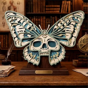 Puede incluir: Escultura de madera en capas de una mariposa con diseño de calavera. Las alas son azules y crema, sobre una base de madera oscura. Un artículo de decoración único para el hogar, con temática gótica.