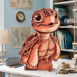Peut inclure: Sculpture en bois en forme de tortue, composée de couches de bois aux tons orangés et beiges. L'œuvre d'art présente un effet 3D avec des découpes détaillées. La tortue repose sur un socle en bois, idéale pour une étagère ou un bureau.