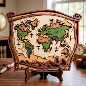 May include: A multi-layered wooden world map in shades of brown, green, and tan, mounted on a wooden stand. The map features detailed cutouts of continents and oceans, with a dark red border. The piece is displayed on a wooden surface.