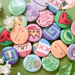 May include: A selection of colourful, round badges with diverse designs. Some badges display geometric shapes, while others have text such as "TNT" and "Touch Grass." The badges are in shades of green, pink, purple, and orange.