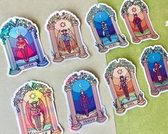 May include: A selection of holographic stickers depicting characters in arched frames. Each sticker presents a character with a name at the base, set against a backdrop of celestial elements and decorative foliage, with a shimmering effect.