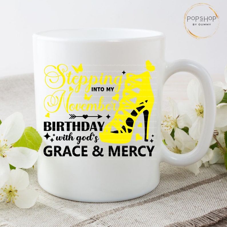May include: White ceramic mug with a yellow and black design. The design features a high-heeled shoe with the text "Stepping into my November Birthday with God's Grace & Mercy".