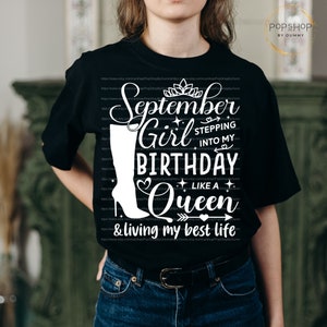 K&ouml;nnte beinhalten: Schwarzes T-Shirt mit wei&szlig;em Text, der "September Girl Stepping into My Birthday Like a Queen & Living My Best Life" lautet. Der Text ist von Herzen, Sternen und einer Krone umgeben. Links vom Text befindet sich eine wei&szlig;e Stiefelgrafik.