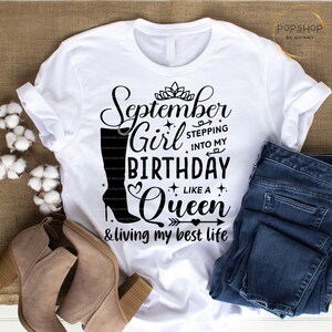 K&ouml;nnte beinhalten: Wei&szlig;es T-Shirt mit schwarzem Text, der "September Girl Stepping into My Birthday Like a Queen & living my best life" lautet. Der Text ist mit einer Krone, Herzen und Sternen verziert.