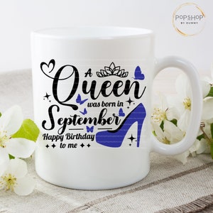 May include: White ceramic mug with a black and blue design. The design features the text "A Queen was born in September" with a crown, butterflies, and a blue high heel shoe. The text "Happy Birthday to me" is also included.