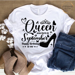 May include: White t-shirt with black text that reads "A Queen was born in September Happy Birthday to me". The text is surrounded by small black butterflies, hearts, and stars. A black high heel shoe is on the bottom right of the shirt.