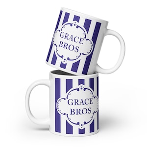 May include: Two white ceramic mugs with blue and white stripes. The mugs have a blue graphic with the text "GRACE BROS" on them.