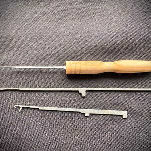 May include: Three crochet hooks, one with a wooden handle and two with metal handles. The wooden handle is light brown and the metal handles are silver.