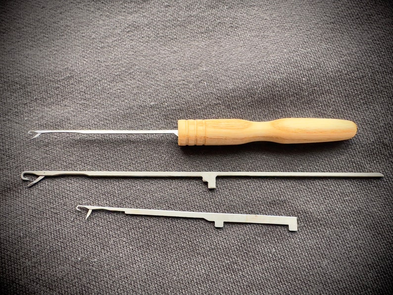 May include: Three crochet hooks, one with a wooden handle and two with metal handles. The wooden handle is light brown and the metal handles are silver.