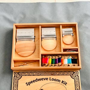 May include: A wooden Speedweve Loom Kit with three looms of varying sizes, a needle, and spools of colorful thread. The kit includes a wooden box with compartments to hold the looms and accessories. The text "Speedweve Loom Kit" is visible on the box.