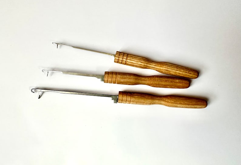 Pu&ograve; includere: Tre uncinetti con manici in legno e punte in metallo. Gli uncinetti sono di diverse dimensioni.