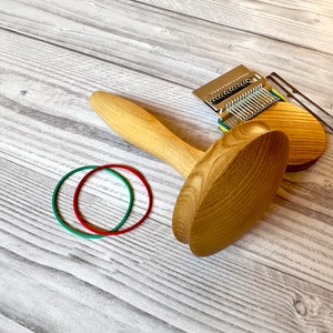 Puede incluir: Dos telares de punto de madera con mango, una aguja de tejer de metal y dos gomas el&aacute;sticas de color rojo y verde.
