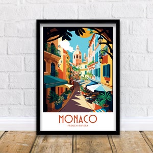 May include: A colorful illustration of a street scene in Monaco, French Riviera. The image features a narrow street lined with colorful buildings, palm trees, and outdoor cafes. The text "MONACO FRENCH RIVIERA" is displayed at the bottom of the image.