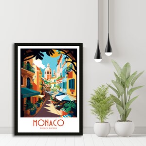May include: A colorful illustration of a street scene in Monaco, France. The image features a narrow street lined with colorful buildings, palm trees, and outdoor cafes. The text "MONACO FRENCH RIVIERA" is at the bottom of the image.