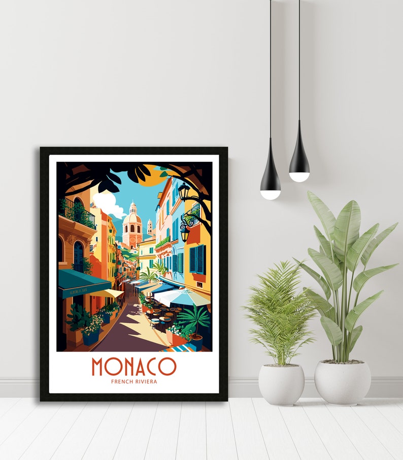 May include: A colorful illustration of a street scene in Monaco, France. The image features a narrow street lined with colorful buildings, palm trees, and outdoor cafes. The text "MONACO FRENCH RIVIERA" is at the bottom of the image.