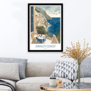 Może przedstawiać: Winietyczny plakat podr&oacute;żniczy przedstawiający malowniczy widok wybrzeża Amalfi we Włoszech. Plakat przedstawia balkon z widokiem na Morze Śr&oacute;dziemne, st&oacute;ł ustawiony dla dw&oacute;ch os&oacute;b oraz widok kolorowych budynk&oacute;w na zboczu. Tekst na plakacie brzmi "Amalfi Coast, Italy."