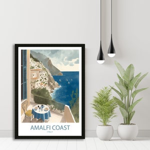 Może przedstawiać: Ilustracja w ramie przedstawiająca kolorową scenę na wybrzeżu Amalfi we Włoszech. Obraz przedstawia balkon z widokiem na ocean z stołem i krzesłami ustawionymi dla dw&oacute;ch os&oacute;b. Tekst "Amalfi Coast" i "Italy" jest wydrukowany pod obrazem.