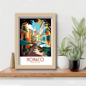 May include: A colorful illustration of a street scene in Monaco, France. The image features a narrow street lined with colorful buildings, palm trees, and outdoor cafes. The text "MONACO FRENCH RIVIERA" is displayed at the bottom of the image.