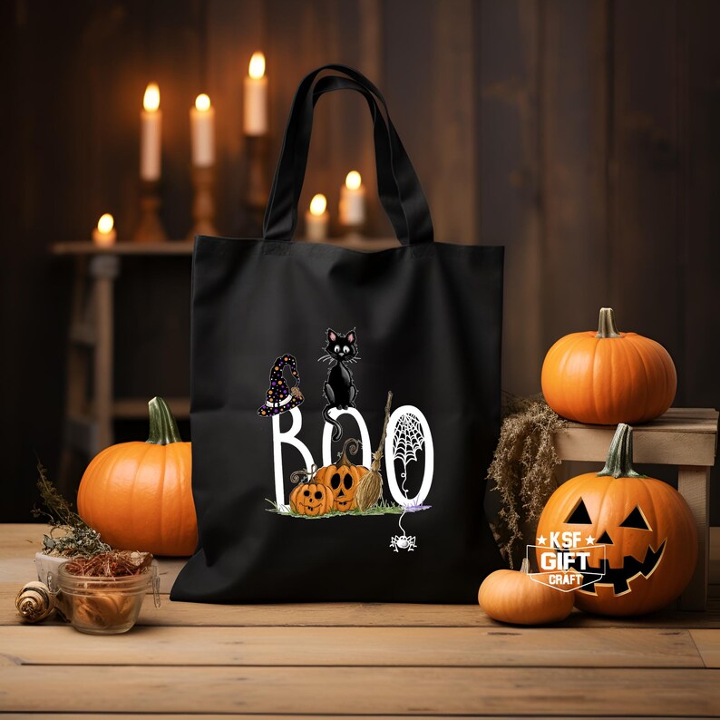 May include: Black tote bag with a white "BOO" graphic featuring a black cat, a witch's hat, pumpkins, and a spider web.