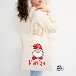 May include: A white canvas tote bag with red and white gnome illustration and the name "Marilyn" printed on the front.
