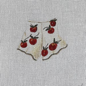 May include: A needlepoint canvas featuring a design of red cherries with green stems on a white apron-like shape. The cherries are arranged in a pattern, with a scalloped edge on the apron. The background is a light, textured fabric.