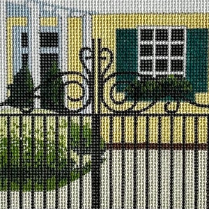 May include: A black wrought iron gate with decorative scrolls in front of a yellow house with a green window and shutters. The house has a white porch and a white roof.