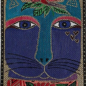 May include: A colourful, rectangular needlepoint depicting a stylized cat's face. The cat has blue fur, teal facial features, and is decorated with floral and leaf accents in red, pink, and green. The artwork is framed with a black and gold border.