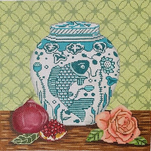 May include: Needlepoint canvas featuring a white and teal decorative jar with a fish design. A red fig and a pink rose are on a brown surface in front of the jar. The background is a light green pattern.