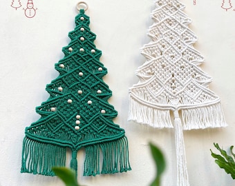 Könnte beinhalten: Zwei Makramee-Wandbehänge in Form von Weihnachtsbäumen, einer in Dunkelgrün und einer in Cremeweiß. Jeder Baum zeigt komplexe Knotenmuster, kleine Holzperlen und einen gefransten Boden mit einer zentralen Quaste. Der Text "Merry Christmas" steht in rotem Draht darüber, und "lindecormacramestore.etsy.com" ist unten aufgedruckt.