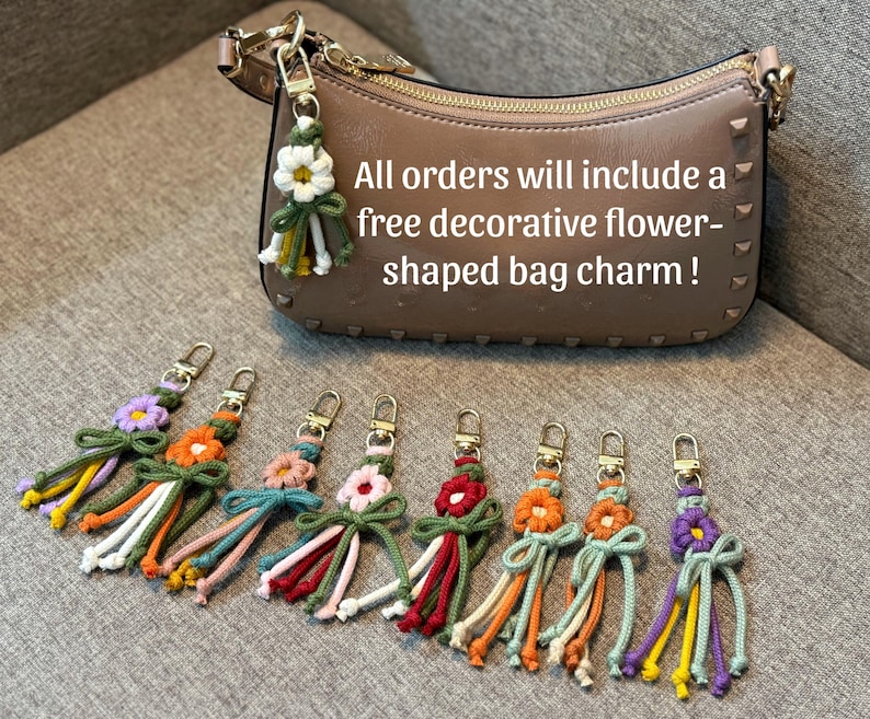 May include: A beige leather handbag with gold hardware and a series of colorful macrame flower bag charms. Each charm features a central flower, a knotted bow, and dangling cord tassels in various colors including purple, orange, pink, and red.